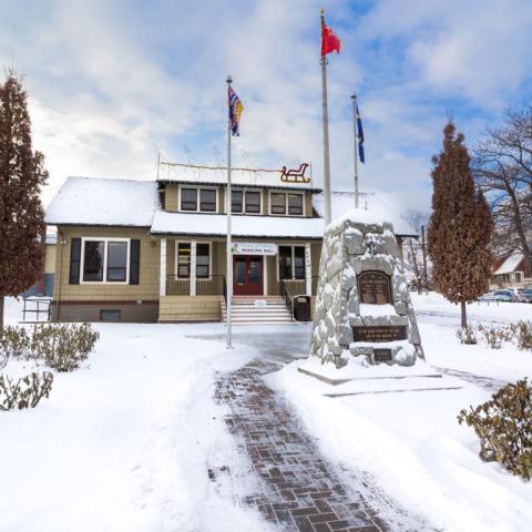 A brown building at the end of a snowy driveway